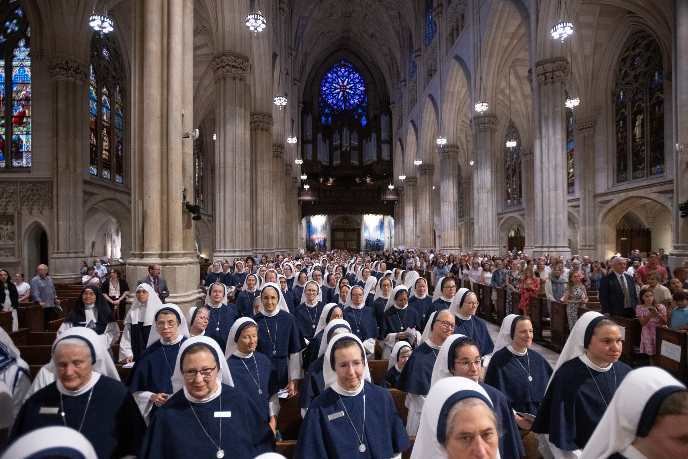 A procession of Sisters of Life fills the cathedral nave beneath the rose window.