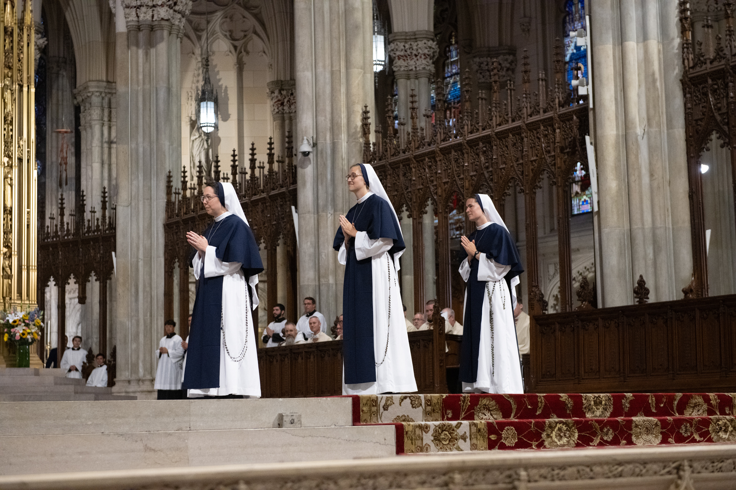 From left: Sister Eden Marie, S.V.; Sister Elena Marie, S.V.; and Sister Maria Annunciata, S.V., stand in prayer before the altar.