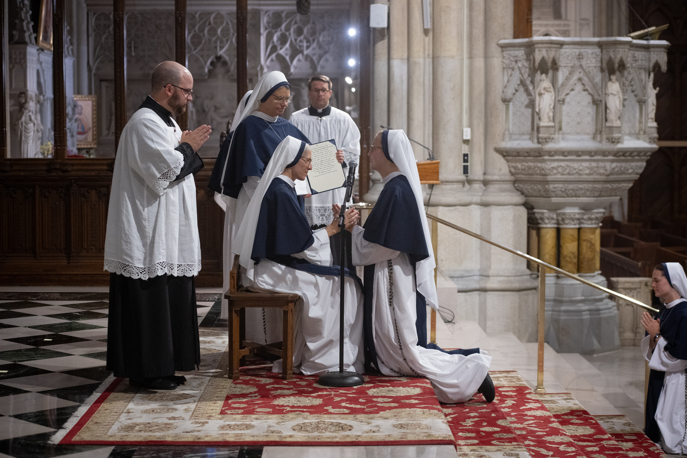Sister Elena Marie, S.V., kneels before Mother Mary Concepta to profess her vows.