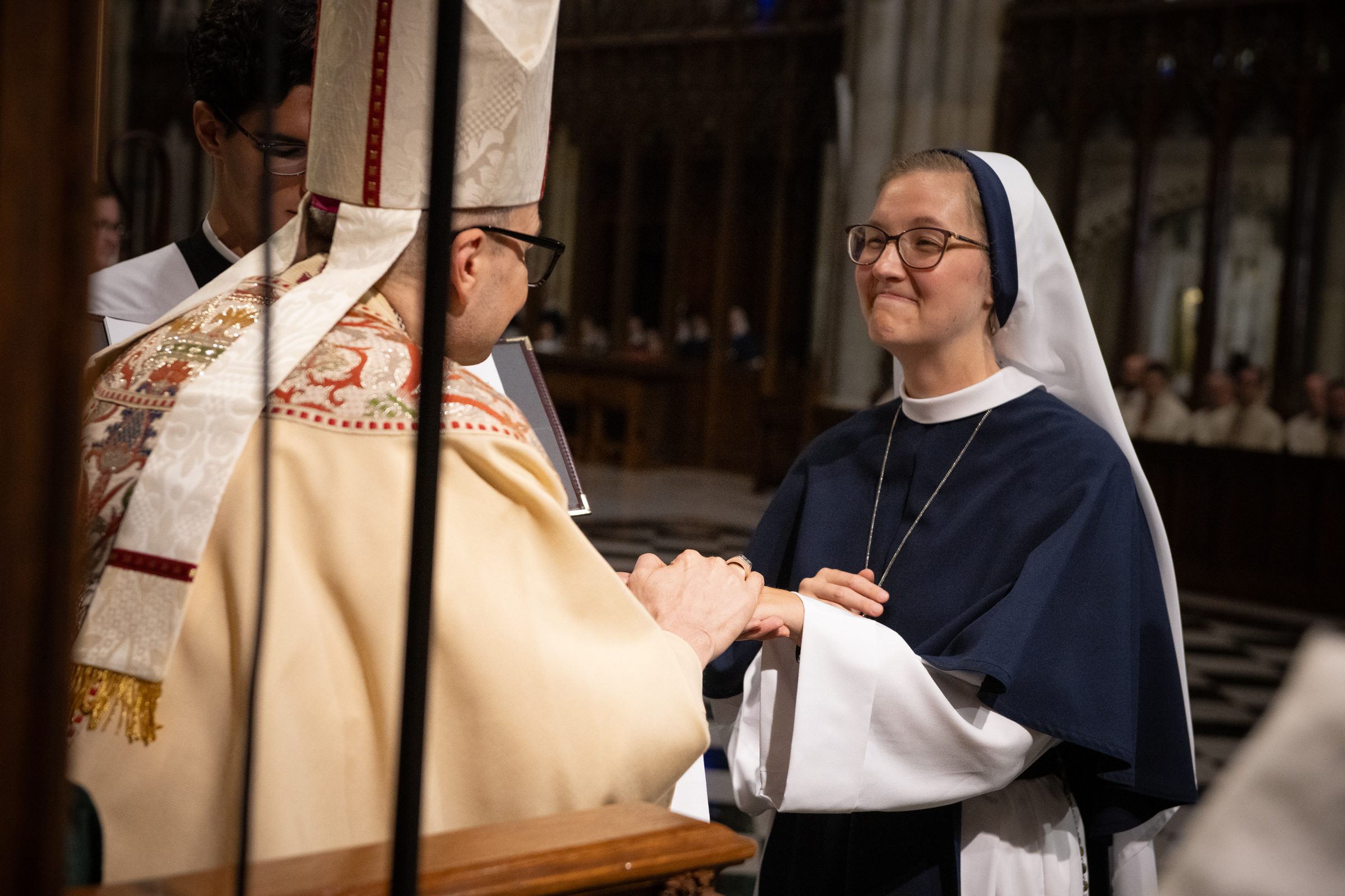 Sister Elena Marie, S.V., looks toward Archbishop Hicks as he presents her profession ring.