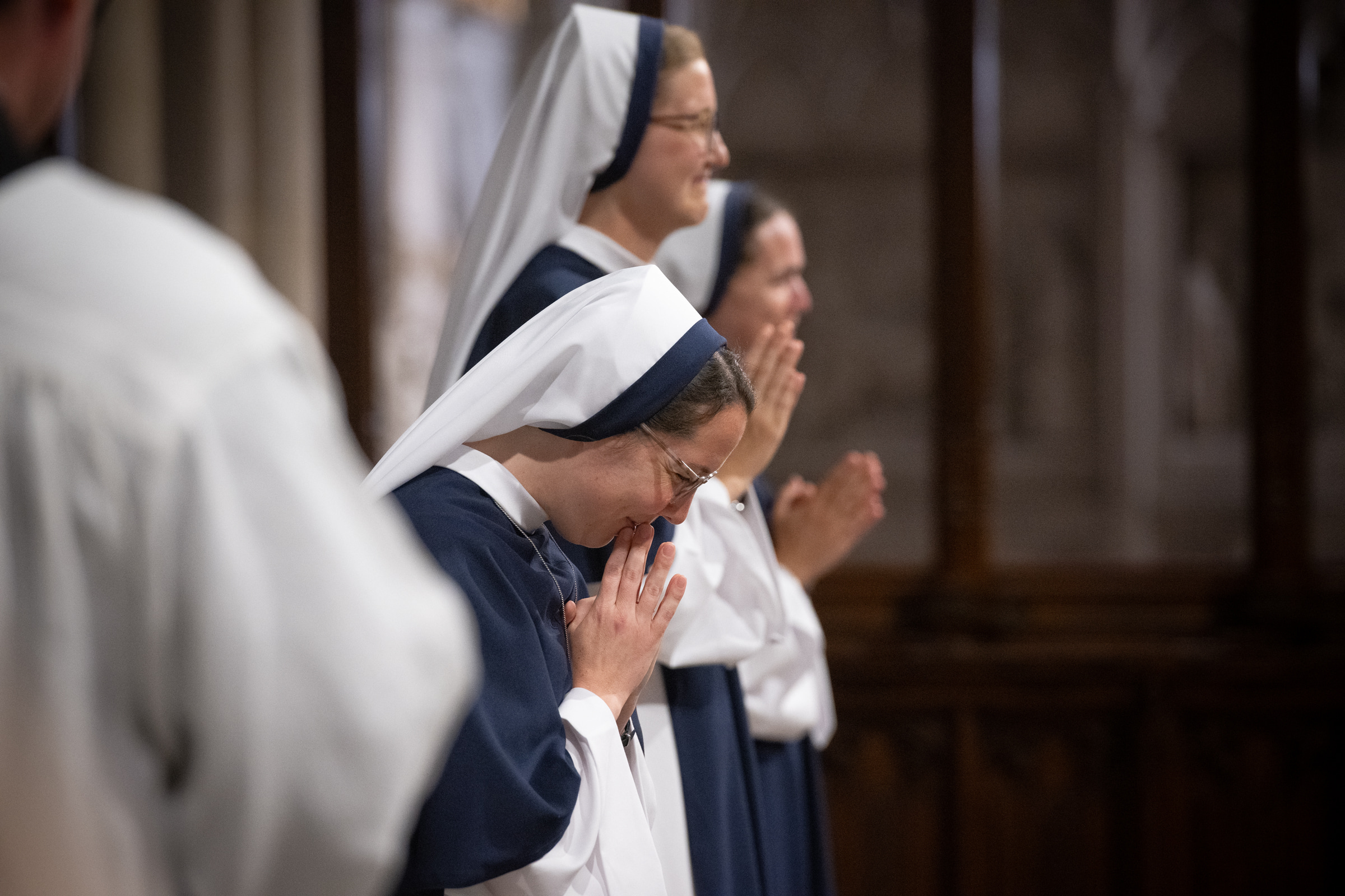 Sister Eden Marie, S.V., bows in prayer as Sister Elena Marie, S.V., and Sister Maria Annunciata, S.V., smile behind her.